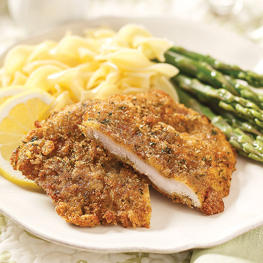 Golden breaded pork schnitzel on a plate with pasta and asparagus shown as serving suggestions.