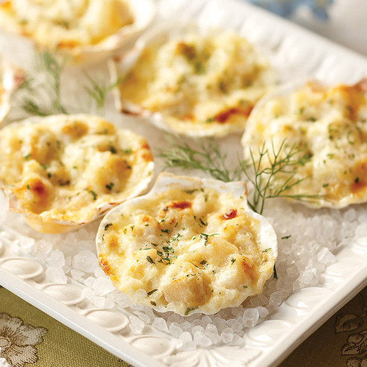 Individual scallop gratins in white shells with golden cheese topping; twelve 1.75 oz portions per order.