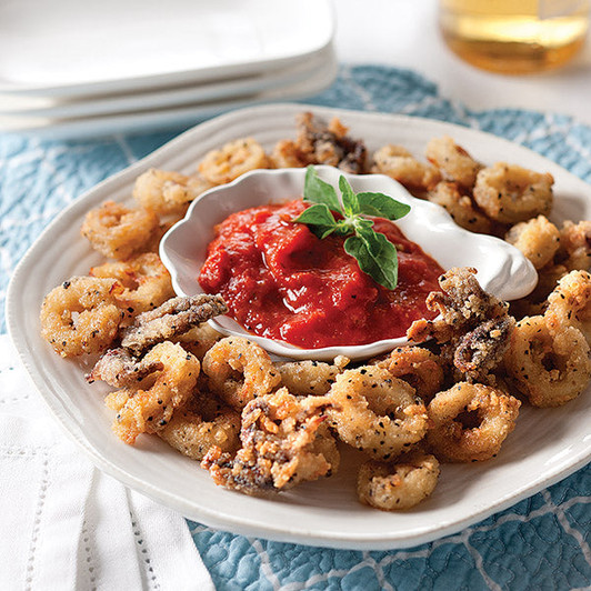 Breaded Fried Calamari on a platter with a dipping sauce