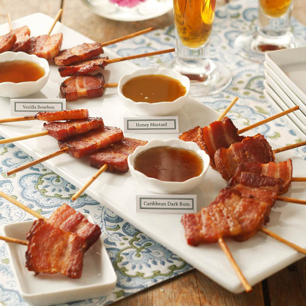Bacon lollipop sampler serving arrangement with skewered bacon and several dipping sauces.