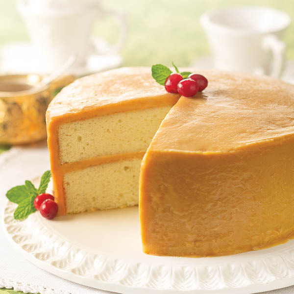 Two-layer caramel-iced yellow cake pictured with a festive garnish; garnish is a serving suggestion.