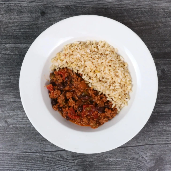 Top-down view of turkey chili with herb brown rice