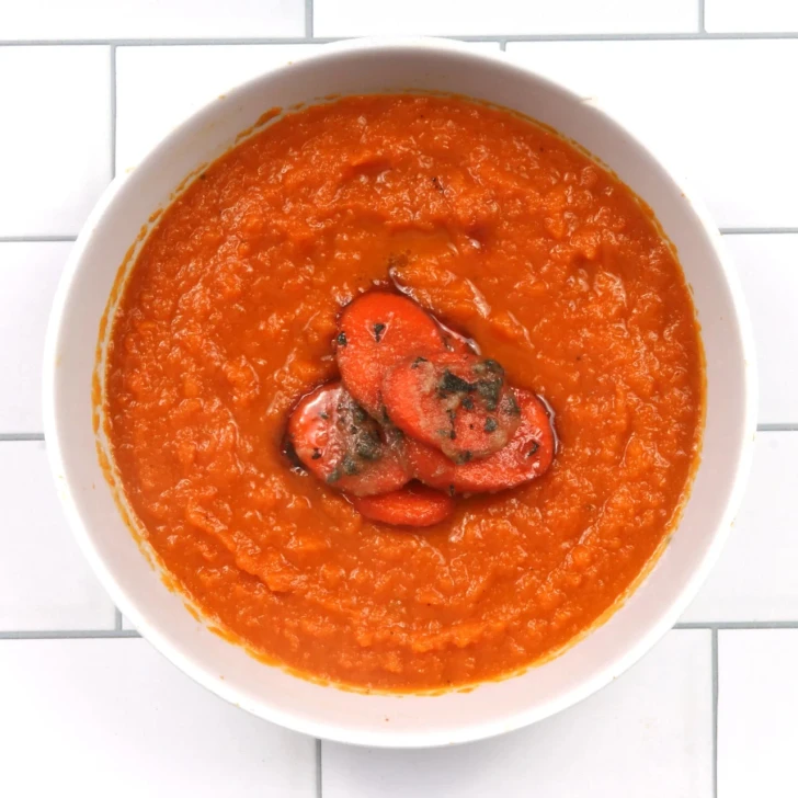 Top-down view of carrot ginger soup in a white bowl