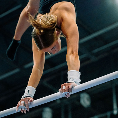 Athlete on bars with Wolf Wear Beginner Buckle Uneven Bar Grips