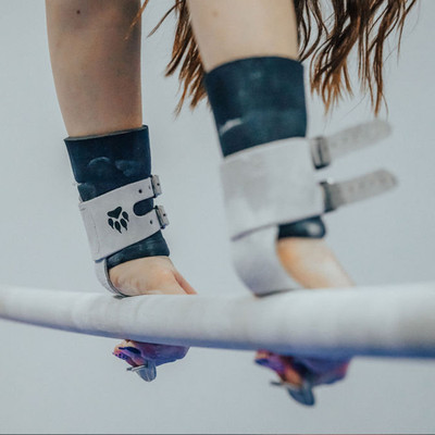 Athlete on bars with Wolf Wear ALPHA Double Buckle Uneven Bar Grips