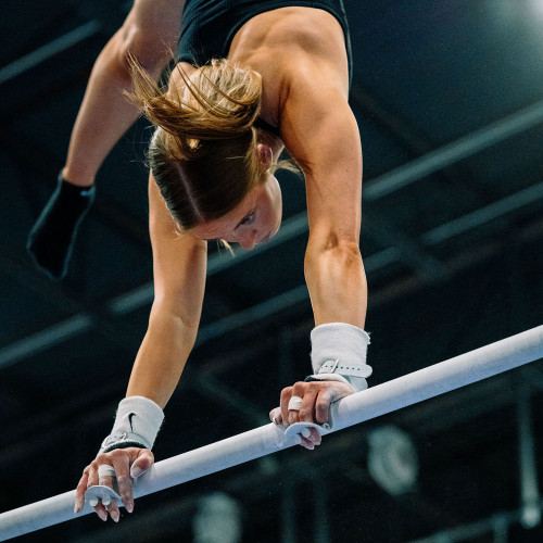 Athlete on bars with Wolf Wear Beginner Buckle Uneven Bar Grips