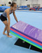 Athlete places a mat on top of a pair of black Tumbl Trak Non-Slip Smart Mat Sheet