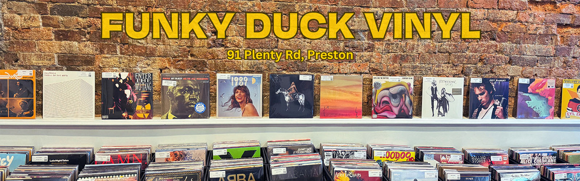 Website Banner picture of the inside of Funky Duck Vinyl Record Store at 91 Plenty Rd, Preston in Melbourne showing  a collection of vinyl records against a brick wall