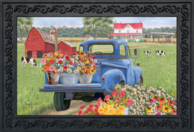 Briarwood Lane Day On The Farm Spring Doormat with colorful flowers and barn on a blue truck.