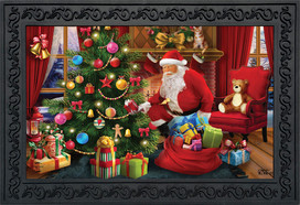 Briarwood Lane's small, printed, decorative doormat depicts Santa near a festive holiday tree with gifts.