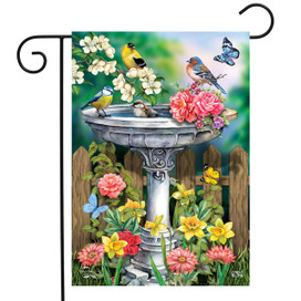 Briarwood Lane Birdbath in Bloom Garden Flag with colorful flowers, birds, and butterflies on fence background.