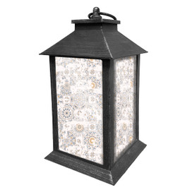 Distressed black metal lantern with white and gold patterned glass panels and roof handle.