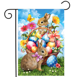 Springtime Bunnies Garden Flag with two brown bunnies, Easter eggs, flowers against blue sky background.