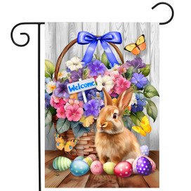 Welcome Bunny and Basket Garden Flag with colorful eggs, flowers, and butterflies on wooden floor.