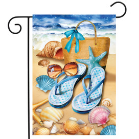 Welcome To the Beach Flip Flop Garden Flag with seashells and starfish on sandy beach.