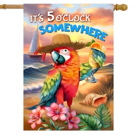 Vibrant parrot in hat holds cocktail on beach with flowers, sunset, and sailboat in background.