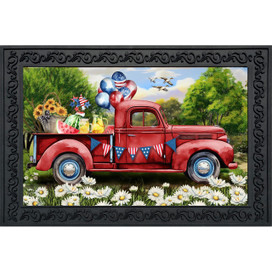 Red vintage pickup truck with picnic items and patriotic decorations on a floral doormat background.