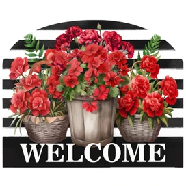 Red striped geraniums in wicker baskets on a black and white striped welcome sign board.