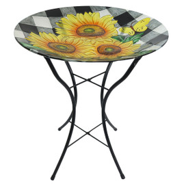 Round glass table with black metal base, checkered sunflowers design, and yellow sunflower pattern on top.