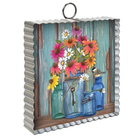 Metal mini moment decor with colorful flowers in glass jars on a rustic blue wooden background.