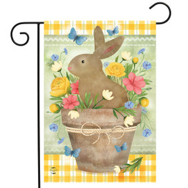 Brown bunny in a flowerpot with colorful flowers and butterflies on a garden flag with yellow trim.