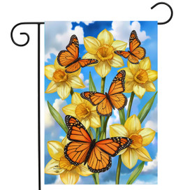 Monarch Butterflies Garden Flag with yellow daffodils and orange butterflies on blue cloudy sky background.