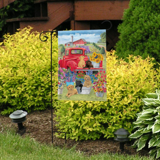 Briarwood Lane Spring Day Puppies garden flag with colorful dog and springtime design on display outdoors.