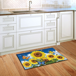 Briarwood Lane Sunflowers and Bees Summer Doormat on a wooden kitchen floor beside white cabinets.