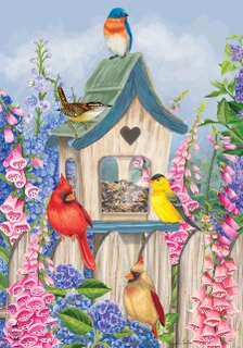 Briarwood Lane spring yard flag with bluebirds, cardinals, flowers, and birdhouse on a fence.
