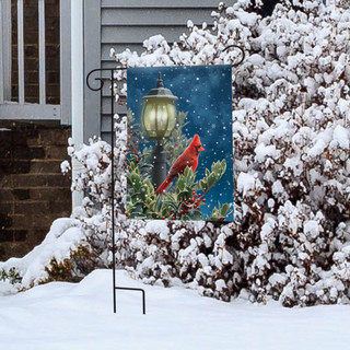 Briarwood Lane Winter Solitude Cardinal garden flag on a stand in snowy yard with lamp post.