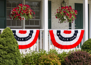 Briarwood Lane Patriotic Bunting 48"x24" USA american flag decoration on a house porch rail.