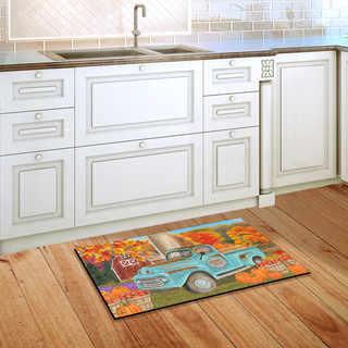 Briarwood Lane colorful printed doormat with fall truck scene on kitchen floor beside white cabinets.