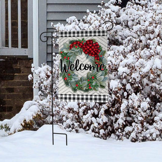 Briarwood Lane Winter Wreath Welcome Garden Flag with berries, spruce, and bow on snowy porch display.