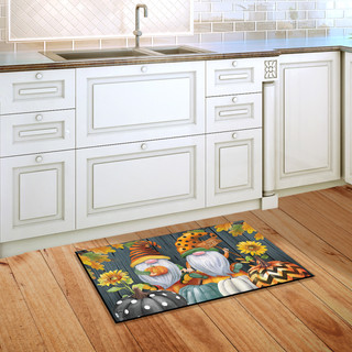 Briarwood Lane Fall Gnomes Humor Doormat on a wooden kitchen floor beside white cabinets.