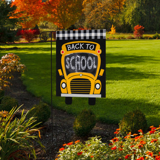Briarwood Lane Back to School burlap garden flag with colorful school bus design on a lawn.