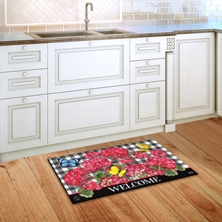 Briarwood Lane small printed doormat with colorful floral, butterflies, and checkers, reading welcome on kitchen floor.