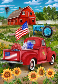 Red Briarwood Lane pickup truck with American flag and sunflowers in a country farm setting.