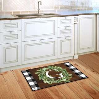 Briarwood Lane Wreath Monogram Letter G doormat on wooden floor in front of white kitchen cabinets.
