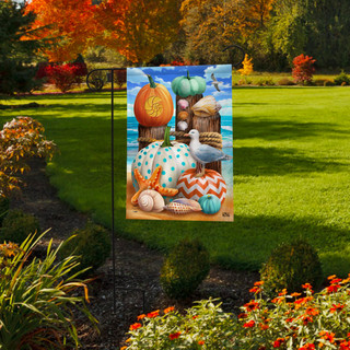 Briarwood Lane Seaside Fall Garden Flag with autumnal pumpkin and seashell design outdoors.