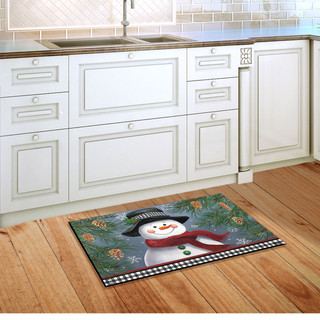 Briarwood Lane Smiling Snowman Doormat on a wooden kitchen floor with white cabinets background.