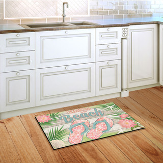 Briarwood Lane Welcome Beach Flip Flops doormat on wooden floor in front of white kitchen cabinets.