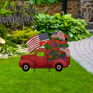 Red Briarwood Lane Stars and Stripes Truck Metal Art with flowers and American flags outdoors.