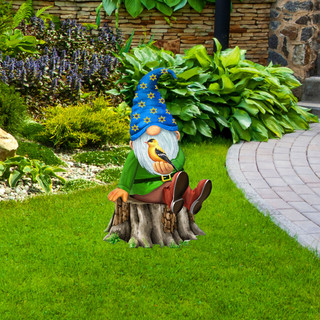 Briarwood Lane Gnome Sweet Gnome Metal Art sitting on tree stump in garden with blue hat.