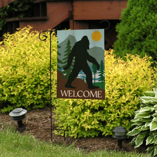 Briarwood Lane Bigfoot Welcome Garden Flag with silhouette design and welcome text on metal stand outdoors.
