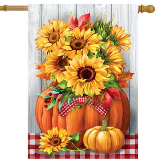 Sunflowers in Pumpkin House Flag with red and white ribbon on a wooden background with tablecloth.