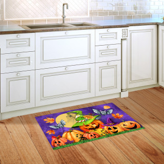 Happy Jack O Lanterns Doormat on wooden kitchen floor with white cabinets and purple background.