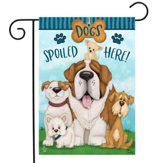 Dogs Spoiled Here garden flag with colorful cartoon dogs and playful design on green grass background.