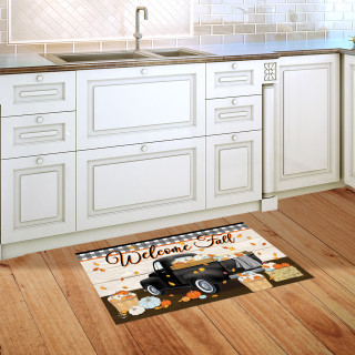 Black truck doormat with Welcome Fall design on kitchen floor with white cabinets.