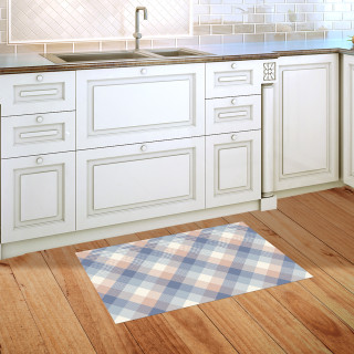 Pink and blue check doormat on wooden floor in front of white kitchen cabinets and sink.