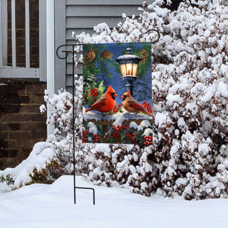 Winter Glow Cardinals Garden Flag with two cardinals, lamp, and snow-covered bushes and flowers.